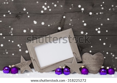 Black and White Christmas Card With Purple Christmas Decoration On White Snow, Snowflakes. Picture Frame With Copy Space, Free Text, Star, Heart And Christmas Tree Ball. Rustic Wooden Background