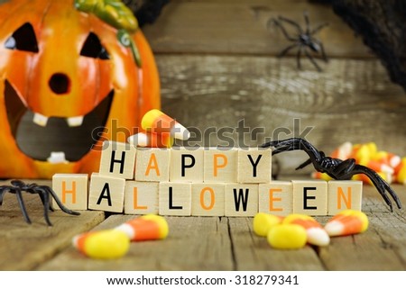 Happy Halloween wooden blocks with candy corn and decor against an old wood background Royalty-Free Stock Photo #318279341