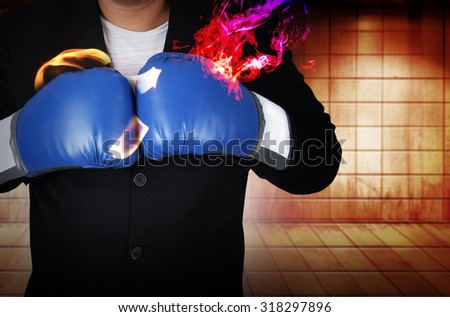 Businessman in boxing gloves with fire