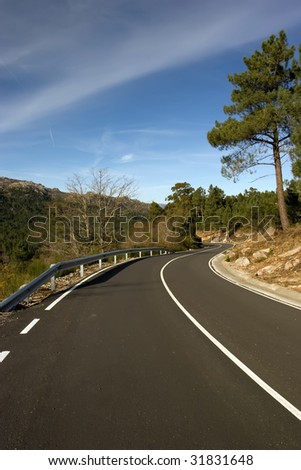 Mountain road with many curves, in blue sky background