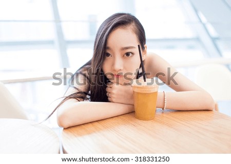 chinese pretty girl, sitting alone in a coffee shop mall rest