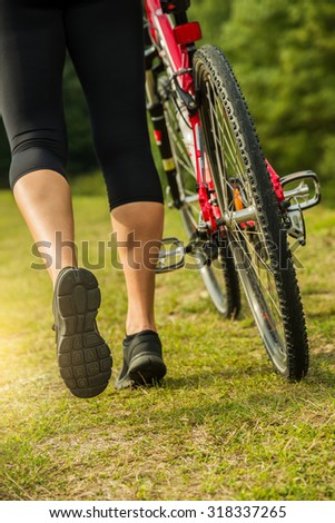 Young biker woman's leg in the field.