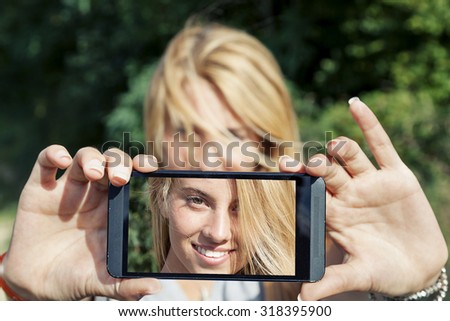 pretty woman with blond hair take a selfie with smart phone