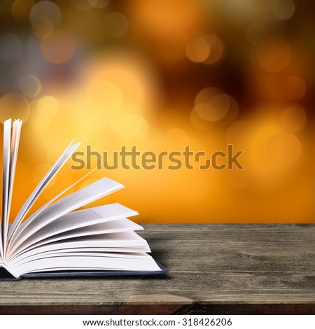 Open book with bokeh light on dark abstract background