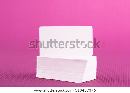 Stack of business cards on pink background