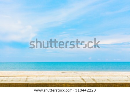 image of wooden table top on blur sea and blue sky background. can used for display or montage your products