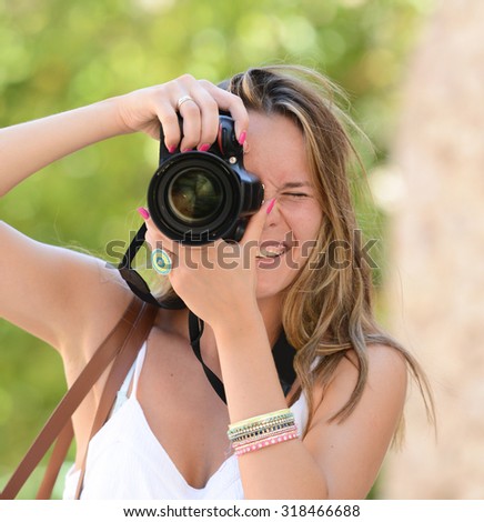 Happy woman photographer holding a dslr camera