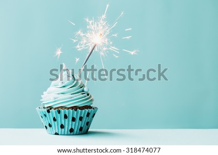 Cupcake with sparkler against blue