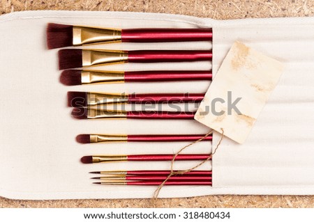 Professional makeup brushes on wood background - top view