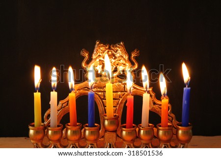 Image of jewish holiday Hanukkah background with menorah (traditional candelabra) Burning candles over black background
