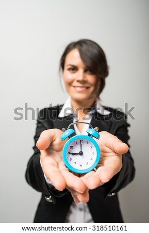 Business women holding an alarm clock in hands
