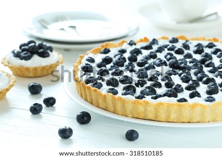 Sweet tart cake with blueberries on white wooden background