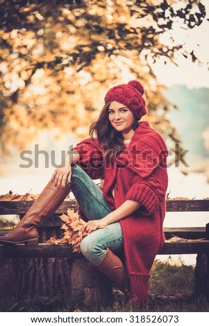 Beautiful woman wearing knitted coat in autumn park 