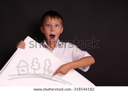 Smiling boy standing with empty horizontal blank in hands, isolated on black