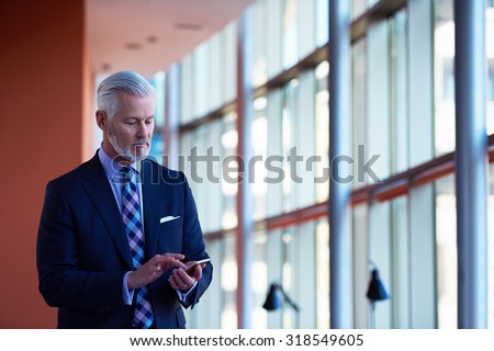 senior business man talk on mobile phone  at modern bright office interior Royalty-Free Stock Photo #318549605