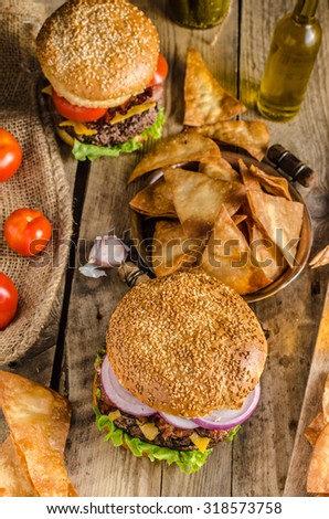 American rustic bacon burger with cheddar, beef, salad and vegetable, old school picture, with czech beer and original homemade nachos with honey mustard dip, place for advertising