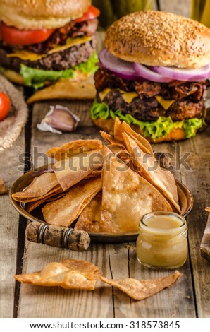 American rustic bacon burger with cheddar, beef, salad and vegetable, old school picture, with czech beer and original homemade nachos with honey mustard dip, place for advertising