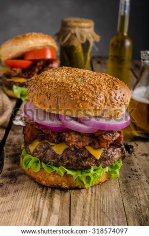 American rustic bacon burger with cheddar, beef, salad and vegetable, old school picture, with czech beer, place for advertising