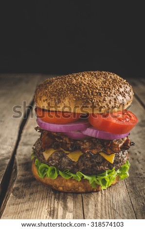 American rustic bacon burger with cheddar, beef, salad and vegetable, old school picture, place for advertising