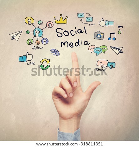 Hand pointing to Social Media concept on light brown wall background