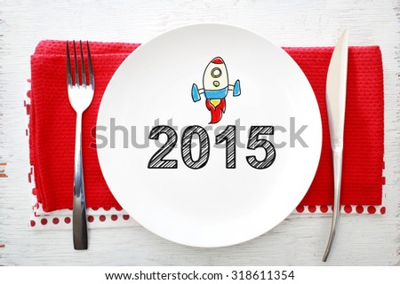 2015 concept on white plate with fork and knife on red napkins