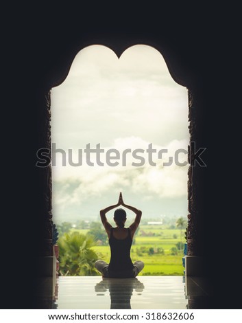Silhouette of a beautiful Yoga woman in the morning, vintage style color effect
