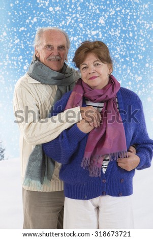 Elderly happy couple over snow blue background