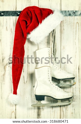 Red Santa Claus hat and white ice skates. Vintage style christmas decoration. Retro toned
