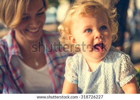 Beautiful blonde toddler girl with her mother. Toned image