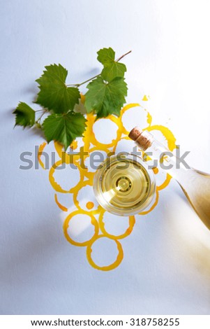 Wine goblet, bottle of wine and corks on picture painted with wine