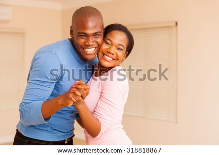 happy young african american couple dancing in their new house