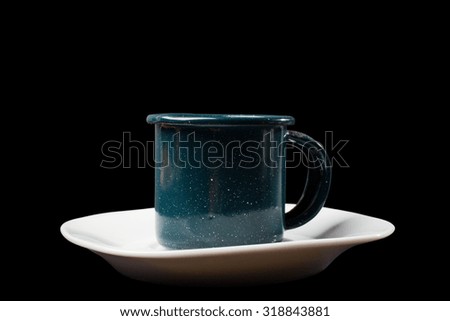 Metal mug isolated on black background with a long shadow.