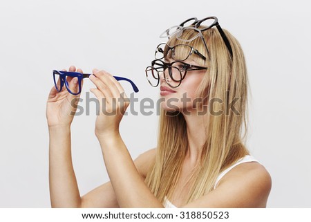 Young blond student choosing spectacles