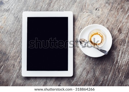 Blank digital tablet and cup of coffee on a wooden table