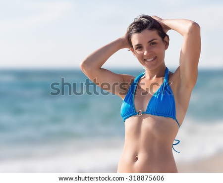 A girl in a bikini relaxes in the sea under the sun