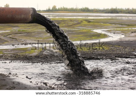 Industrial pipe discharging liquid waste Royalty-Free Stock Photo #318885746