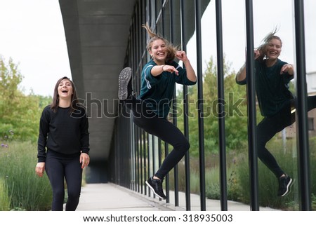 Two girls having fun and jumping with a kick