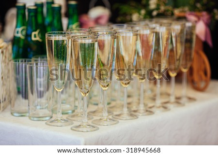 Dish with champagne and wine glasses. On outdoor wedding reception in summer. Royalty-Free Stock Photo #318945668