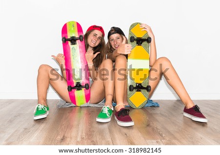 Friends with their skateboards with thumb up