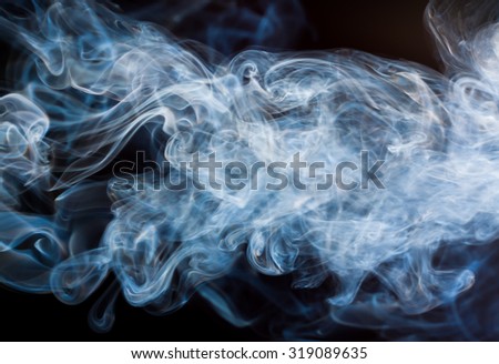 Blue and white smoke abstract on black background, darkness concept