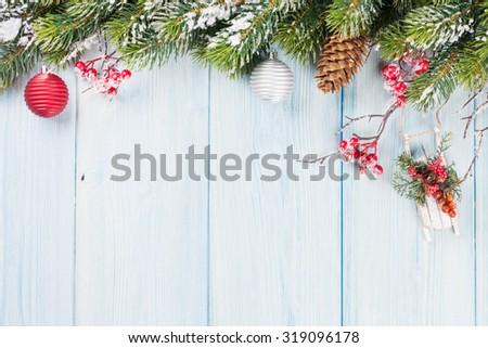 Christmas wooden background with snow fir tree and holiday decor