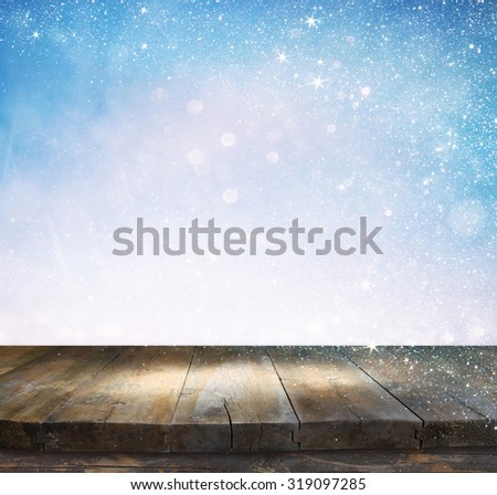 rustic wood table in front of glitter silver and white bright bokeh lights
