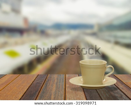 Steaming coffee cup on window background. A view of The train tracks.