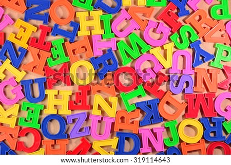Colorful plastic alphabet letters on a wooden background 