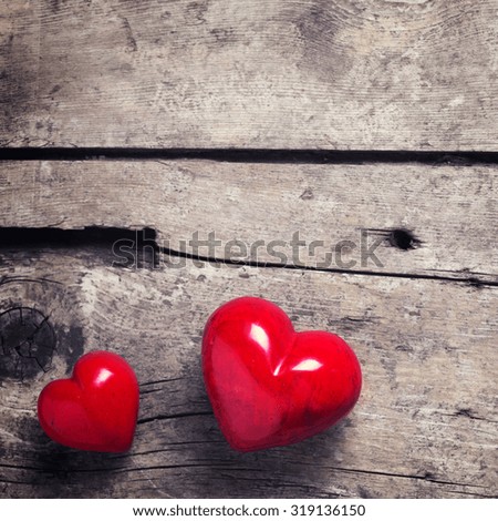Red hearts on aged wooden background. Selective focus. Place for text. Square image.
