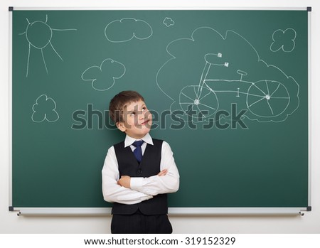 dreaming school boy with painted bicycle on board