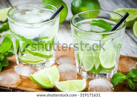 two cold mojitos cocktail on rustic wooden table