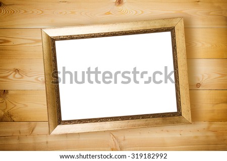Vintage gilded frame on wooden wall background 