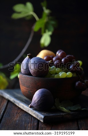 figs and grapes in a wooden bowl, rustic still life