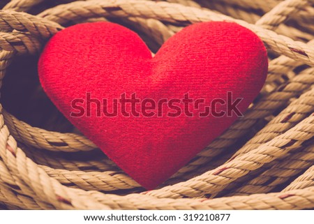 Valentine day background. Red heart with rope. Retro filter.